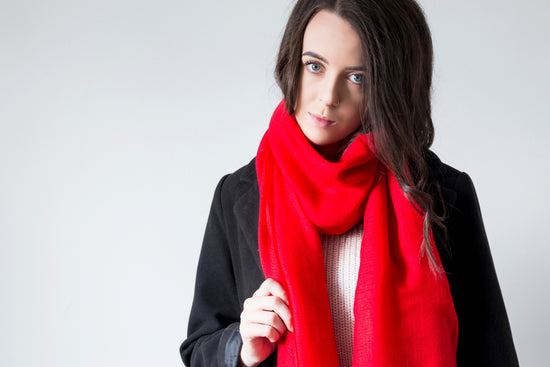 Model wearing a crimson red 100% cashmere wrap scarf handmade in Nepal with ethically sourced wool